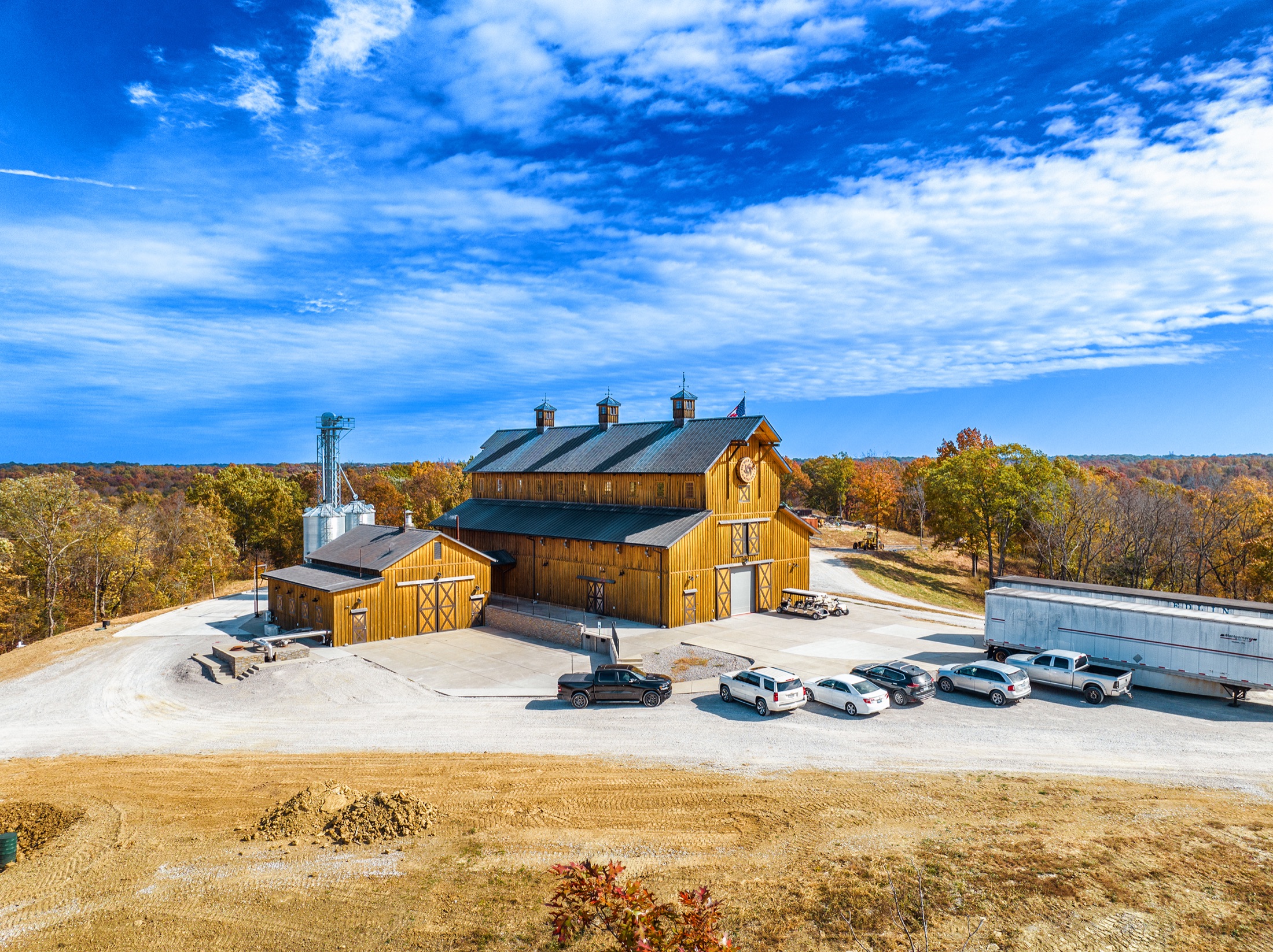 Aerial photograph of a Kentucky barn and grain bins on a hilltop in autumn, shot by Shaun Wilson