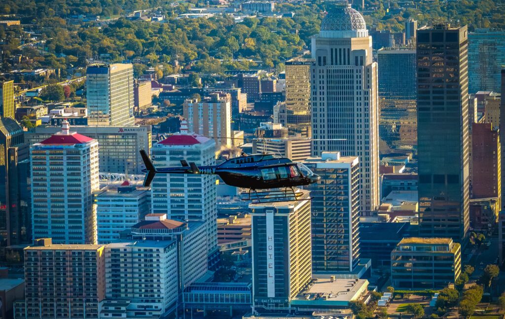 Air-to-air helicopter photograph over downtown Louisville at golden hour