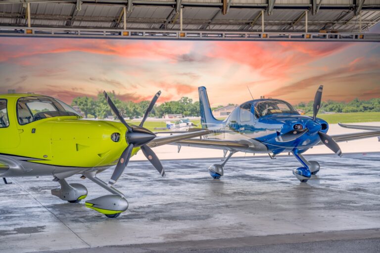 Yellow and blue Cirrus aircraft in the hangar at sunset, Bowman Field Louisville