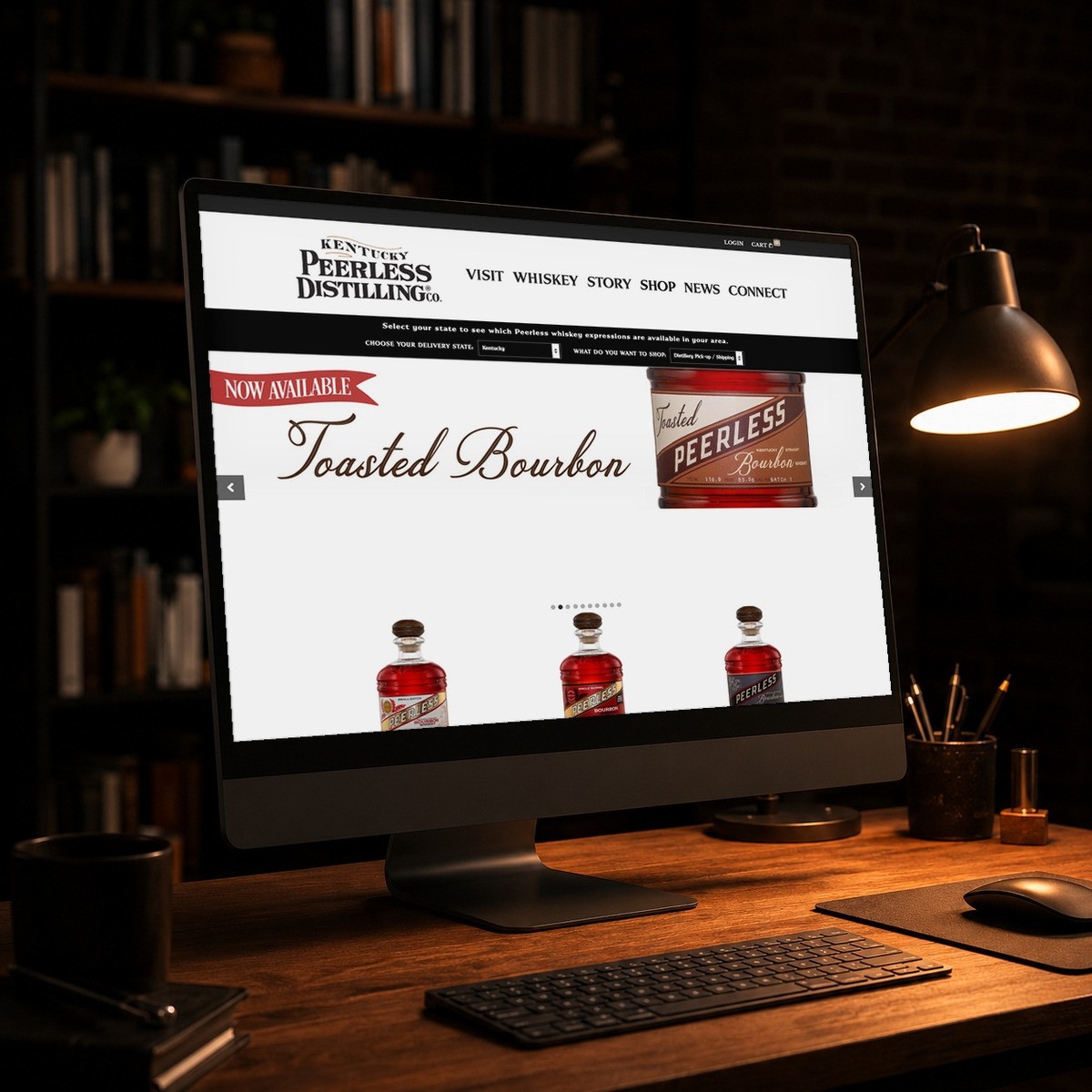Shop Peerless bourbon store on a desktop monitor in a dark studio, e-commerce design by Shaun Wilson Designs in Louisville