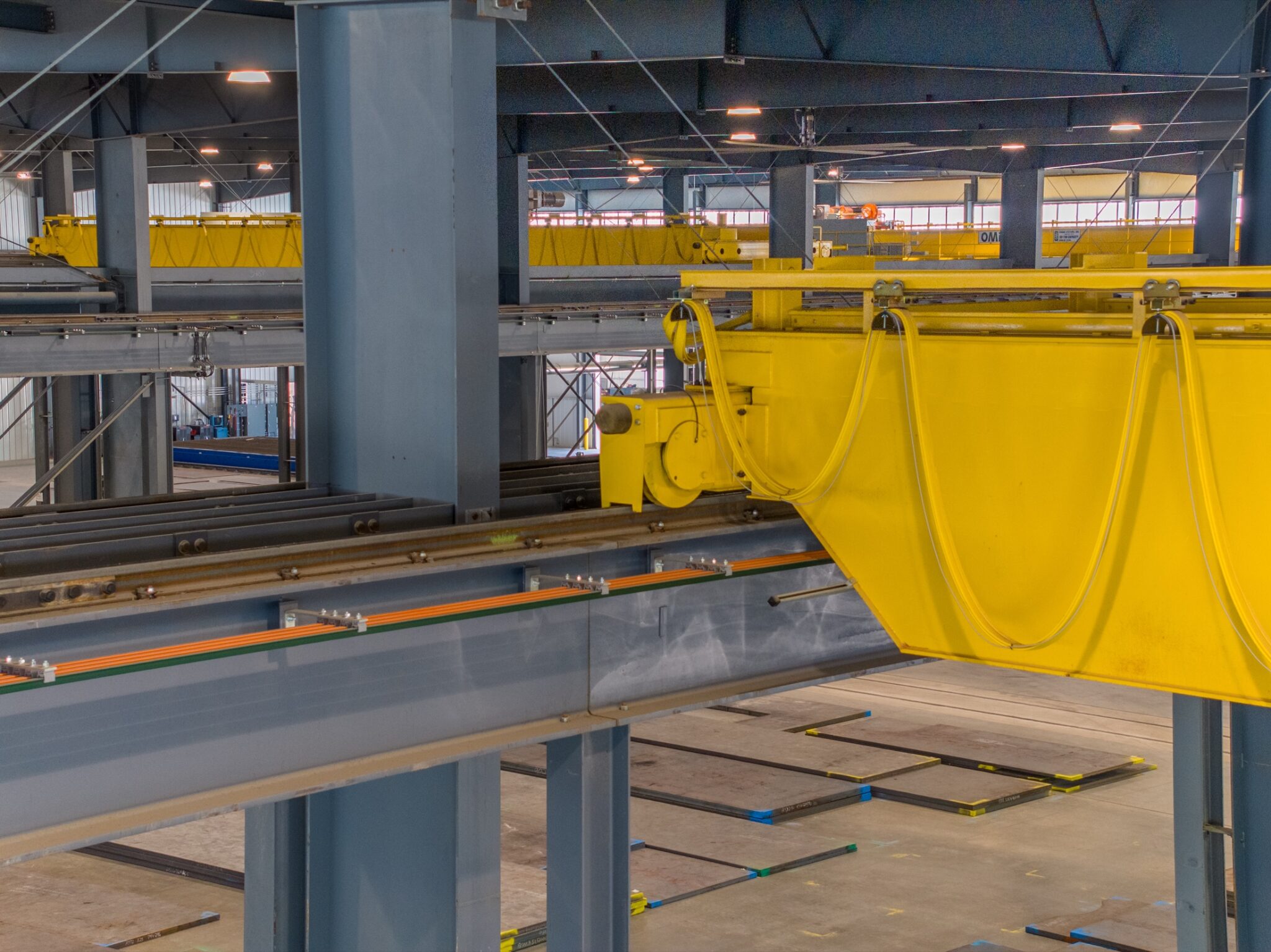 Interior photograph of an industrial facility with overhead crane systems