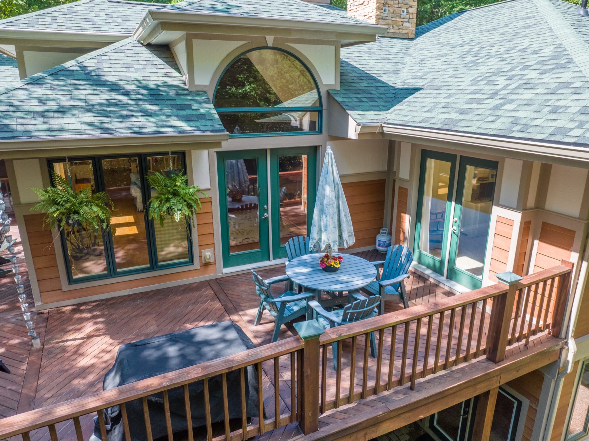Overhead drone view of a lake house deck and outdoor living space