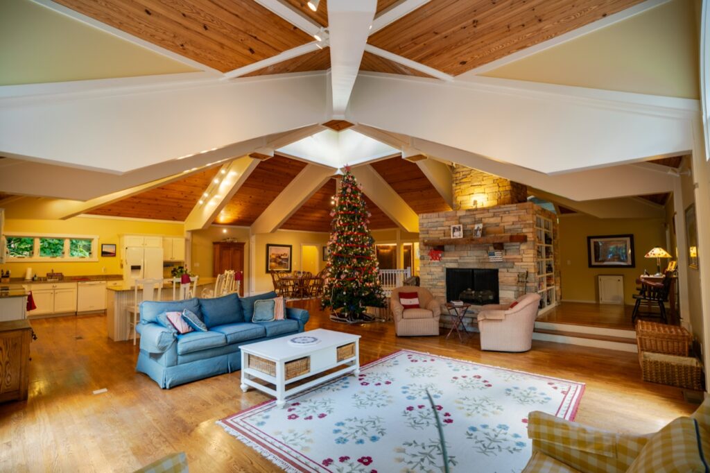 Vaulted great room with exposed beams and stone fireplace, HDR real estate photography