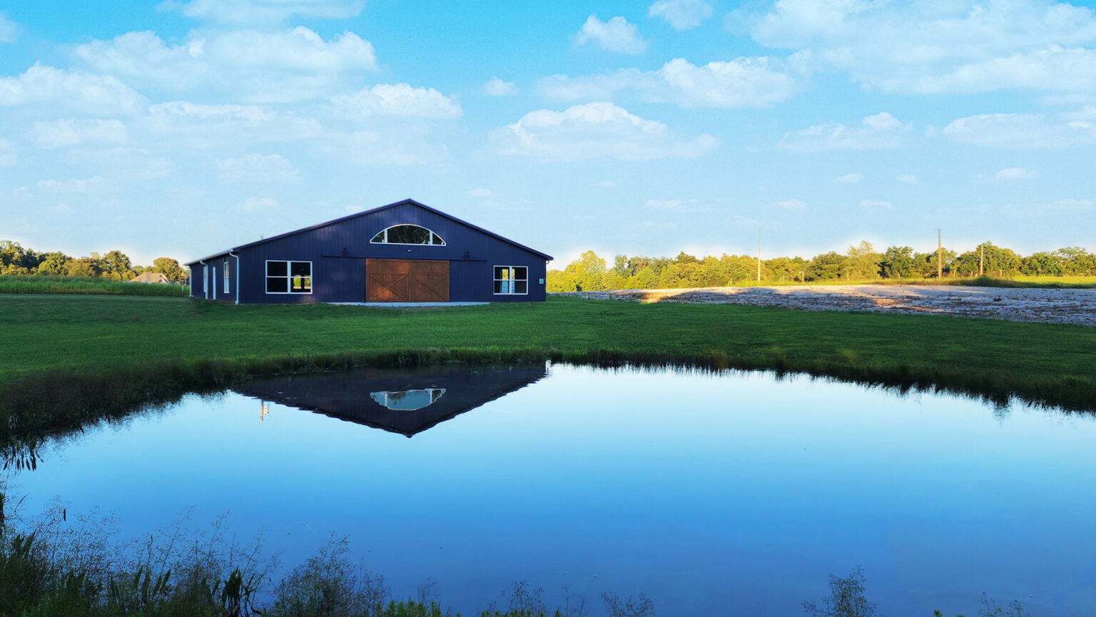 The Old Mill Venue event barn reflected in its pond in Meade County Kentucky
