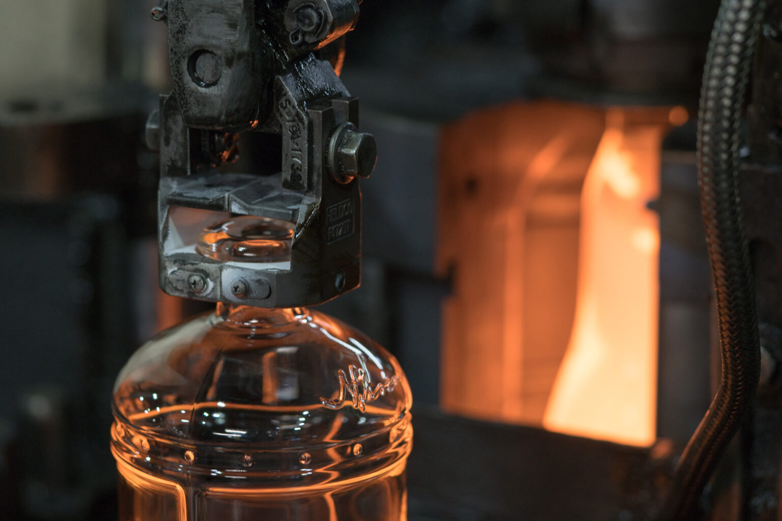 Kentucky Peerless bottle being formed at the glass factory, molten glow behind