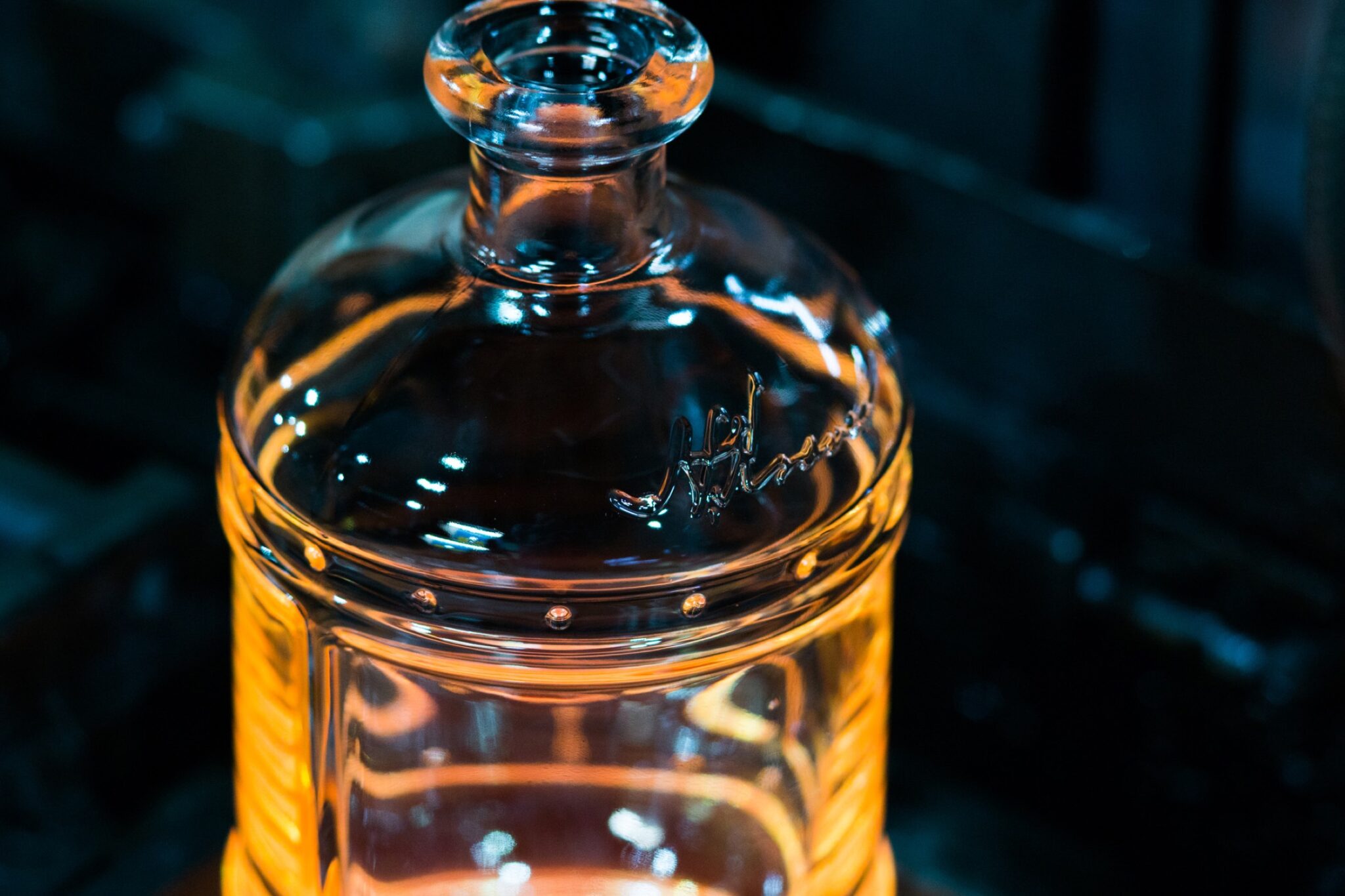 Empty bourbon bottle glowing amber on the bottling line, product photography by Shaun Wilson