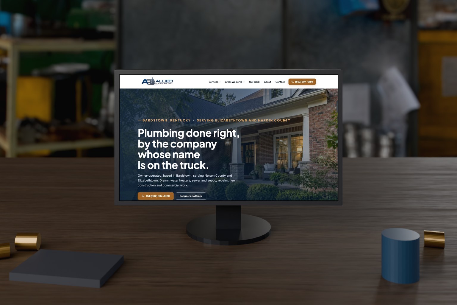 Allied Plumbing website on a monitor in a plumbing service workshop, a site Shaun Wilson Designs hosts and maintains.