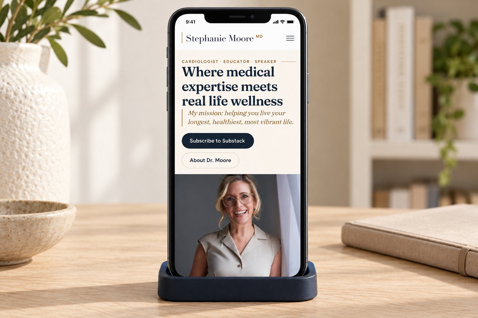 Dr. Stephanie Moore's website on a phone in an editorial study, a presentation scene built from the real site.