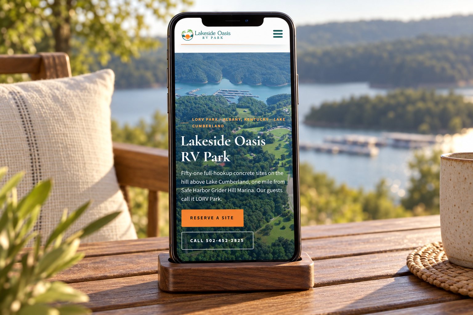 The Lakeside Oasis RV Park website on a phone beside a wooded lake, a presentation scene built from the real site.