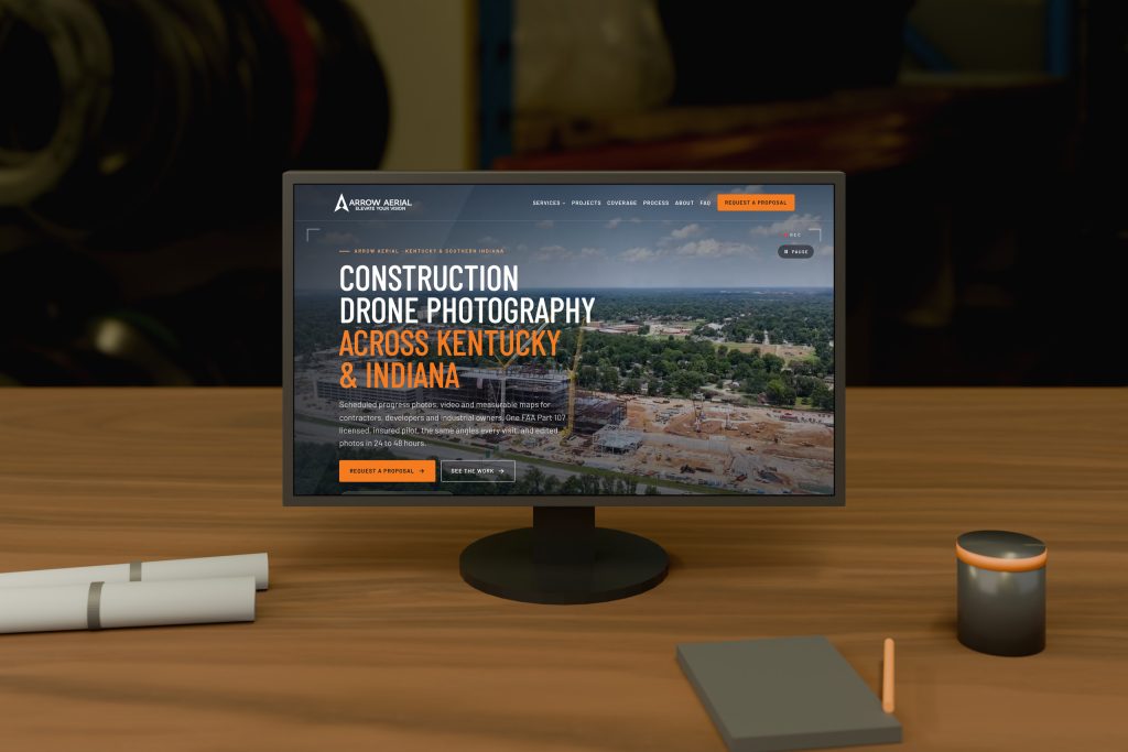 Arrow Aerial website homepage on a desktop monitor in a drone equipment room, by Shaun Wilson Designs