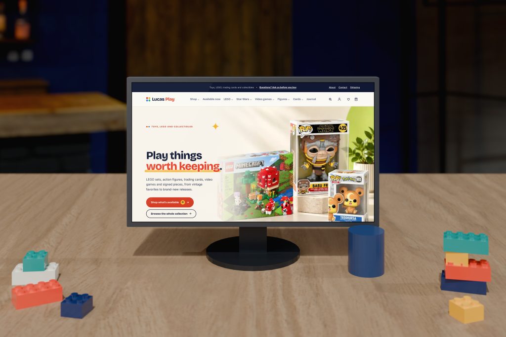 Lucas Play toy and collectibles store homepage on a desktop monitor with toy bricks on the desk, by Shaun Wilson Designs